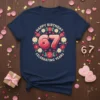 Navy t-shirt with "Happy Birthday 67 Celebrating Years" text surrounded by flowers and hearts, designed for a 67th birthday celebration