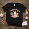 Happy birthday text with cute bear, bunny, and fox celebrating with a cake on a black t-shirt