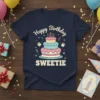 Happy Birthday SWEETIE t-shirt with a colorful tiered cake and candles graphic, surrounded by confetti and gift boxes