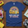 Happy First Day Of School text with school bus and rainbow graphic on a blue t-shirt