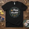 Black t-shirt with "Happy Hanukkah" text surrounded by colorful lights, menorah, dreidels, and gelt