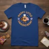 Happy Little Snackcident donut graphic t-shirt with text in a circle, featuring a chef donut character
