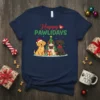 Happy Pawlidays t-shirt design with three cute dogs, a Christmas tree, and presents, featuring festive green and red text