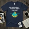 T-shirt with white text "HATING DRAKE DOESN'T MAKE YOU DEEP" above an iceberg graphic with musical notes