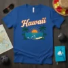 Blue t-shirt with "Hawaii" text in retro font, palm trees, and a sunset over the ocean