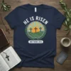 He Is Risen Matthew 28:6 T-Shirt featuring three crosses on a hill with sunburst and laurel wreath graphic