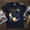 Hello 67 t-shirt design with gold script text, blue glitter number 67, diamond-encrusted high heel, crown, and blue lips graphic