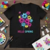 Black t-shirt with colorful "HELLO SPRING" text and a vibrant floral design with pink, blue, and yellow flowers