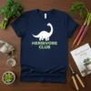 White dinosaur graphic with "Herbivore Club" text in green on a navy t-shirt