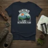 Hiking Is My Retirement Plan quote on a navy t-shirt with a mountain landscape graphic and a hiker silhouette