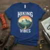 Hiking Vibes t-shirt design with mountain range, pine trees, and sunset graphic
