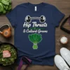 Navy t-shirt with white text "Hip Thrusts & Collard Greens" and a dumbbell graphic above a bunch of collard greens