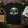 Hobbs Hollow Hollow text above a rustic cabin and pine trees graphic on a black t-shirt