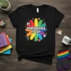 Black t-shirt with "HOMOPHOBIA IS GAY" text in white and a colorful rainbow flower graphic