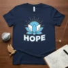 Navy blue t-shirt with the word HOPE in white block letters above a light blue lotus flower graphic with sun