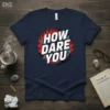 Navy t-shirt with "HOW DARE YOU" in bold white letters surrounded by red flames and blue lightning bolts