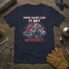 Mechanic kneeling with wrench and car, text "How Hard Can It Be? Boys Do It" on a navy t-shirt design