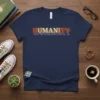 Navy blue t-shirt with the word HUMANITY in colorful retro rainbow lettering, featuring a small rainbow cloud graphic