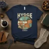 T-shirt design with the words HYGGE time, showing a cozy armchair scene by a winter window with a hot drink