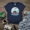 Navy t-shirt with white text "I am AMAZING AT HOME" and a graphic of a person relaxing on a couch