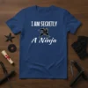 I Am Secretly A Ninja T-Shirt featuring a graphic of a ninja in action with white text on a blue