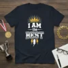 Navy t-shirt with white text "I AM the BEST" and a golden crown graphic above lightning bolts