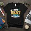 Black t-shirt with "I Beat Beat Teen Pregnancy" in bold yellow, blue, and white text, featuring graduation cap and diploma