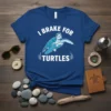 I Brake For Turtles text with a blue sea turtle graphic on a dark navy t-shirt