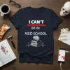 Navy blue t-shirt with white text "I CAN'T IM IN MED SCHOOL" and a graphic of books, a brain, and