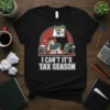I Can't It's Tax Season t-shirt with a stressed cartoon man at a desk piled with papers and a calendar