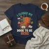 I Closed My Book To Be Here t-shirt design with armchair, sleeping cat, books, and coffee cup