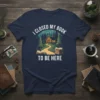 T-shirt design with the text "I Closed My Book To Be Here" featuring a cozy cabin in a forest setting