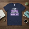 "I Didn't Change You Just Never Knew Me" quote t-shirt in white and purple text on a navy blue shirt