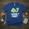 Blue t-shirt with "I Didn't Fart" text and a cute, sad cloud graphic blowing wind