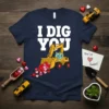 Navy blue t-shirt with white text "I DIG YOU" above a yellow excavator spilling hearts