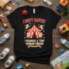 Black t-shirt with "I DON'T BABYSIT I MANAGE A TINY HUMAN CIRCUS" text and cartoon babies in a circus theme