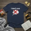 Navy blue t-shirt with white text "I don't care" above a thought bubble containing a sleeping cat wearing sunglasses with