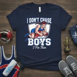 Graphic t-shirt design with the text "I DON'T CHASE BOYS I Pin Them" featuring two female wrestlers in action