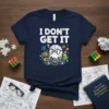 I DON'T GET IT text with a confused cartoon brain wearing glasses on a navy t-shirt, surrounded by colorful science