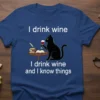 I drink wine I drink wine and I know things quote on a blue t-shirt with a black cat holding
