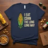 I Eat Corn The Long Long Way funny quote t-shirt with corn graphic, cream text on navy blue tee
