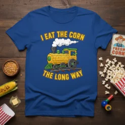 I Eat The Corn The Long Way t-shirt design featuring a corn cob train with smoke and railway tracks