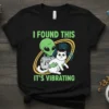 Alien holding a white cat with the text "I Found This It's Vibrating" on a black t-shirt design