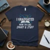 Navy t-shirt with white and blue text "I GRADUATED NOW I'M LIKE SMART & STUFF" and graduation cap graphic