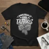 I Have Really Cool Tattoos text design on a black t-shirt, featuring a person with many tattoos and a scarf