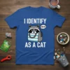 White text "I IDENTIFY AS A CAT" with a cute raccoon holding a striped bag and saying "MEOW" on a