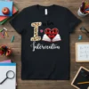 Black t-shirt with "I is for Intervention" text, leopard print 'I', heart with book, and buffalo plaid design