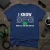 Navy t-shirt with white text "I KNOW WHAT ALL THE BUTTONS DO" above a graphic of DJ turntables and a