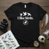 Black t-shirt with white text "I like birds." and a graphic of three flying birds and one perched bird