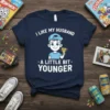 Navy t-shirt with white text "I Like My Husband A Little Bit Younger" and a cartoon boy holding a trophy